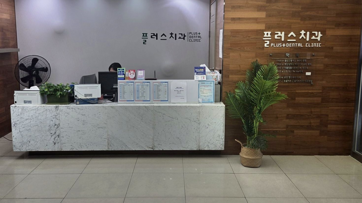 플러스치과의원 메인 로비의 안내 데스크와 실내 공간